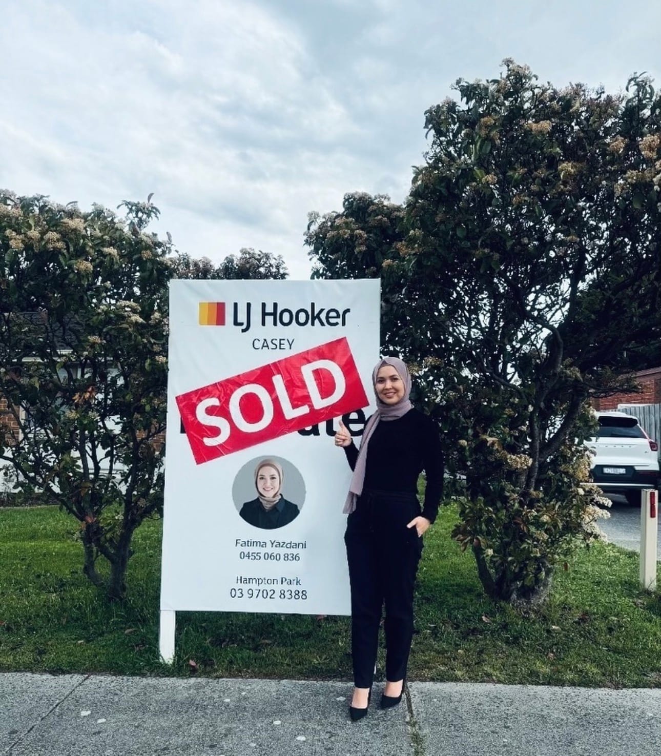 Fatima beside a SOLD board in Hampton Park.