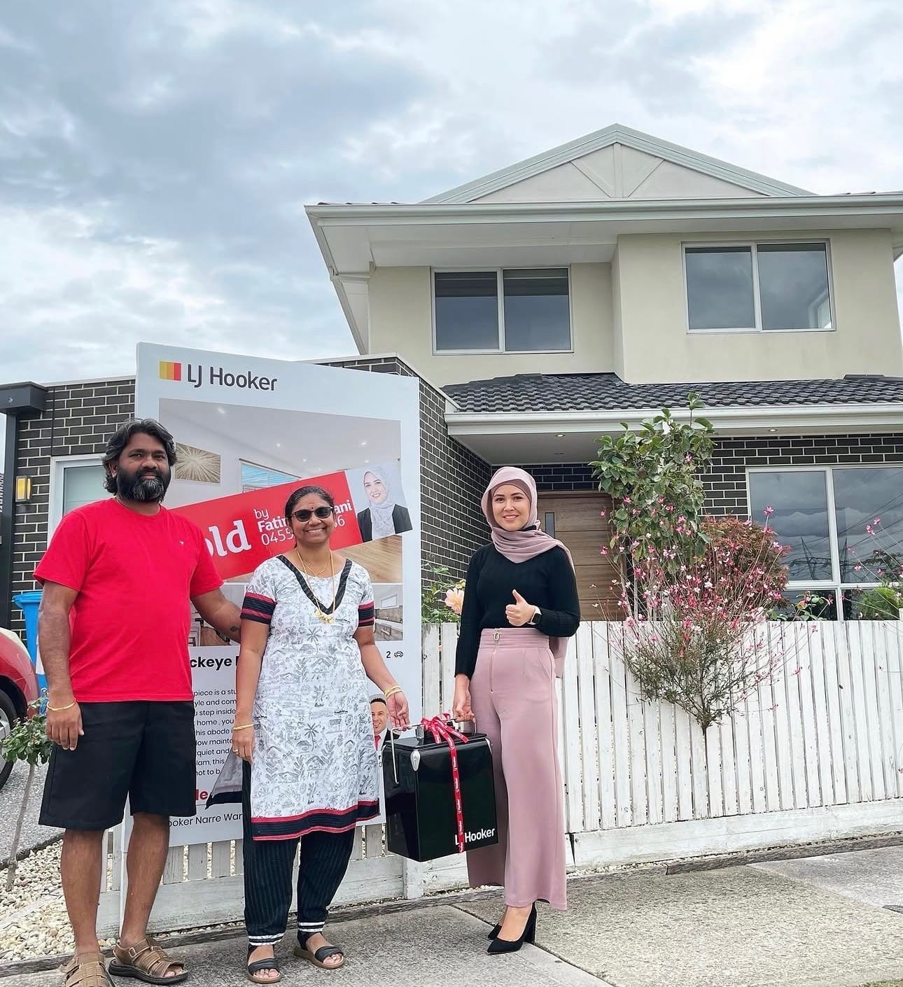 Fatima Yazdani with happy buyers in front of their new home and an LJ Hooker board.